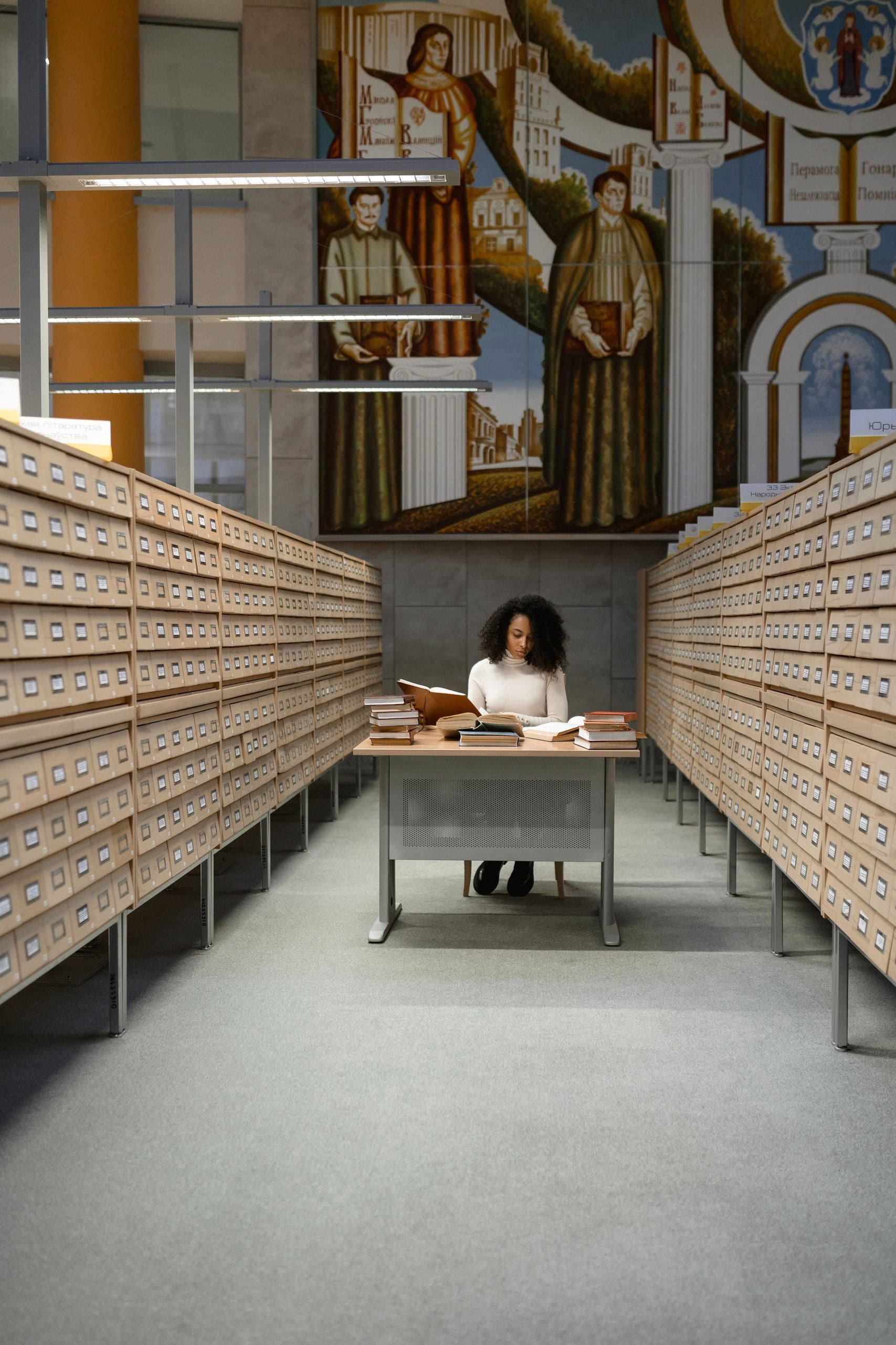 A student studies among rows of library card catalogs, surrounded by books. This article shares lessons on visual storytelling that lasts.